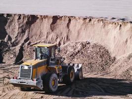 Tractor with a bucket in a sand pit. photo