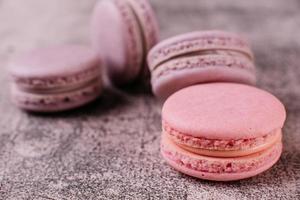 Beautiful pink tasty macaroons on a concrete background photo