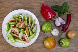 Spicy appetizer of canned pickled red and green tomatoes photo