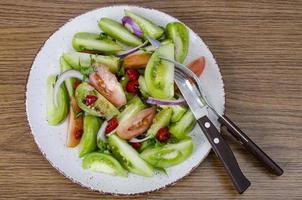 Spicy appetizer of canned pickled red and green tomatoes photo