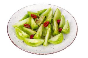 Appetizer of spicy pickled green tomatoes. Studio Photo.