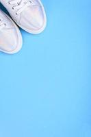 Silver sneakers on a blue background with place for text photo