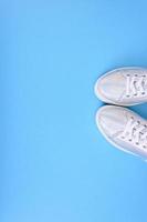 Silver sneakers on a blue background with place for text photo