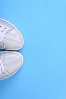 Silver sneakers on a blue background with place for text photo