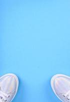 Silver sneakers on a blue background with place for text photo