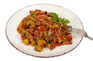 Salteado de verduras de temporada, berenjena con tomates en un plato, bocadillos vegetarianos foto