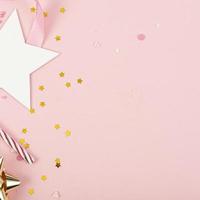 Party Holiday Background with ribbon, stars, birthday candles and confetti on pink background. Studio Photo