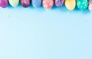 Colorful background with Easter eggs on blue background. Happy Easter concept. Can be used as poster, background, holiday card. Flat lay, top view, copy space. Studio Photo