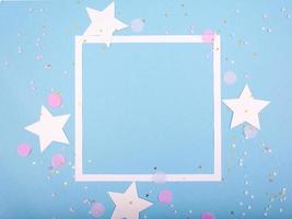 Party Holiday Background with ribbon, stars, birthday candles, gift box empty frame and confetti on blue background photo