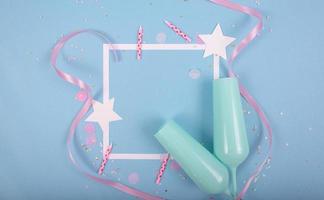 Party Holiday Background with ribbon, stars, birthday candles, empty frame and confetti on blue background photo