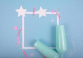 Fondo de vacaciones de fiesta con cinta, estrellas, velas de cumpleaños, marco vacío y confeti sobre fondo azul. foto