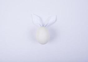 Egg with paper ears in the shape of an Easter bunny. Happy Easter Concept Card Postaer Background photo