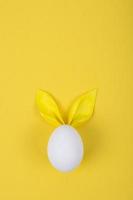 Egg with paper ears in the shape of an Easter bunny. Happy Easter Concept Card Postaer Background photo