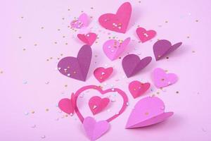 Fondo abstracto con corazones de papel para el día de San Valentín. Fondo rosado de amor y sentimiento para póster, pancarta, postal, tarjeta. vista superior foto