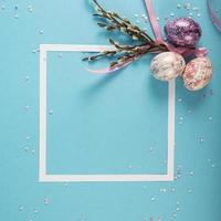 Colorful background with frame, Easter eggs on blue background. Happy Easter concept. Can be used as poster, background, holiday card. Flat lay, top view, copy space. photo