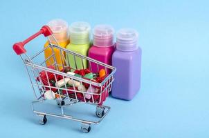 Buy medicine. Shopping basket with various medicinal, pills, tablets on blue background photo