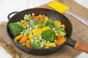 zanahorias congeladas, brócoli y guisantes en una sartén. foto de estudio