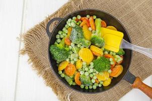 Frozen carrots, broccoli and green peas in frying pan. Studio Photo