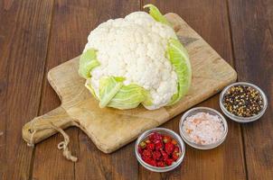 Head of cabbage fresh organic cauliflower on wooden background, spices. Studio Photo