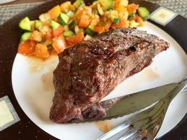Grilled beef steak with vegetables on plate. photo