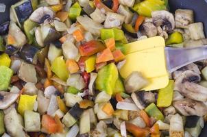 Frying pan with fried seasonal vegetables and mushrooms on white photo