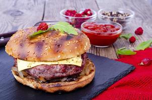 Homemade burger with sesame bun and ground beef on black stone. Studio Photo