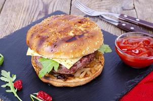 Homemade burger with sesame bun and ground beef on black stone. Studio Photo