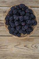 Ripe sweet black blackberries in wooden bowl
