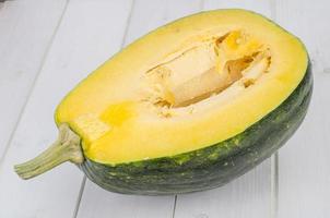 Half ripe butternut squash on wooden surface photo