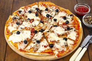 pizza casera con pepperoni, champiñones, mozzarella y aceitunas. foto de estudio