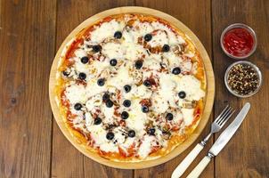 pizza casera con pepperoni, champiñones, mozzarella y aceitunas. foto de estudio