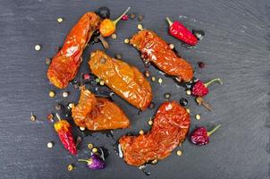 Delicious sun-dried tomatoes on black stone background photo