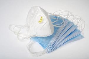 Blue medical disposable masks and white respirators - protection against coronavirus photo