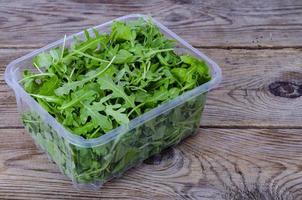 Fresh green arugula on wooden table from old boards. Studio Photo