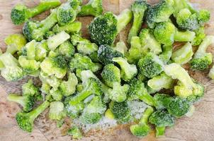 Verduras bio congeladas crudas sobre tabla de cortar de madera. foto de estudio.