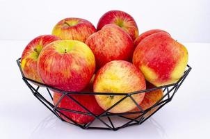 Ripe sweet apples in black metal basket. Studio Photo