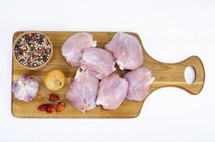 Pieces of cut raw chicken, leg thighs on white background. Studio Photo. photo