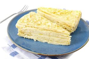 Plate with slice of homemade puff pastry with cream. Studio Photo