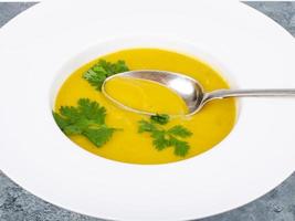 White plate with thick pumpkin cream soup. Studio Photo. photo