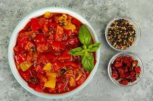 Plato de verduras de pimientos y tomates guisados, lecho, menú vegetariano. foto de estudio.