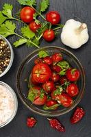 Pickled tomatoes with herbs and garlic. Studio Photo. photo