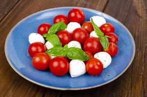 Delicious Italian caprese salad with basil, mozzarella and cherry tomatoes. Studio Photo. photo