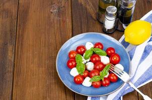 Delicious Italian caprese salad with basil, mozzarella and cherry tomatoes. Studio Photo. photo