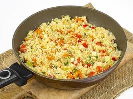 Couscous with vegetables in frying pan. Moroccan cuisine dish. Studio Photo