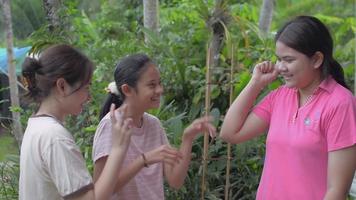 Drei fröhliche thailändische Teenager-Schwestern, die zu Hause zusammen spielen. video