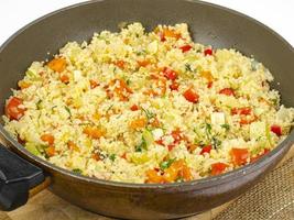 Couscous with vegetables in frying pan. Moroccan cuisine dish. Studio Photo