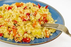 Pilaf de cuscús vegetariano con verduras en placa azul. foto de estudio