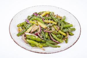 Vegetarian green bean pod dish with red pickled onions and sesame seeds. Studio Photo