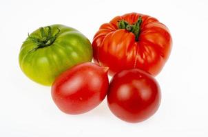 Colored tomatoes of different varieties on white background. Studio Photo