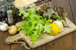 lettuce leaves on wooden cutting board, set of spices for cooking. Studio Photo. photo